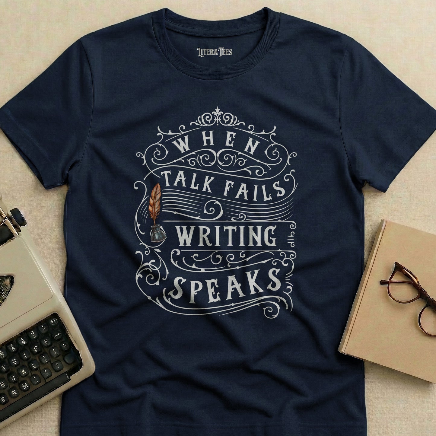 Navy t-shirt with "WHEN TALK FAILS WRITING SPEAKS" text and quill design.