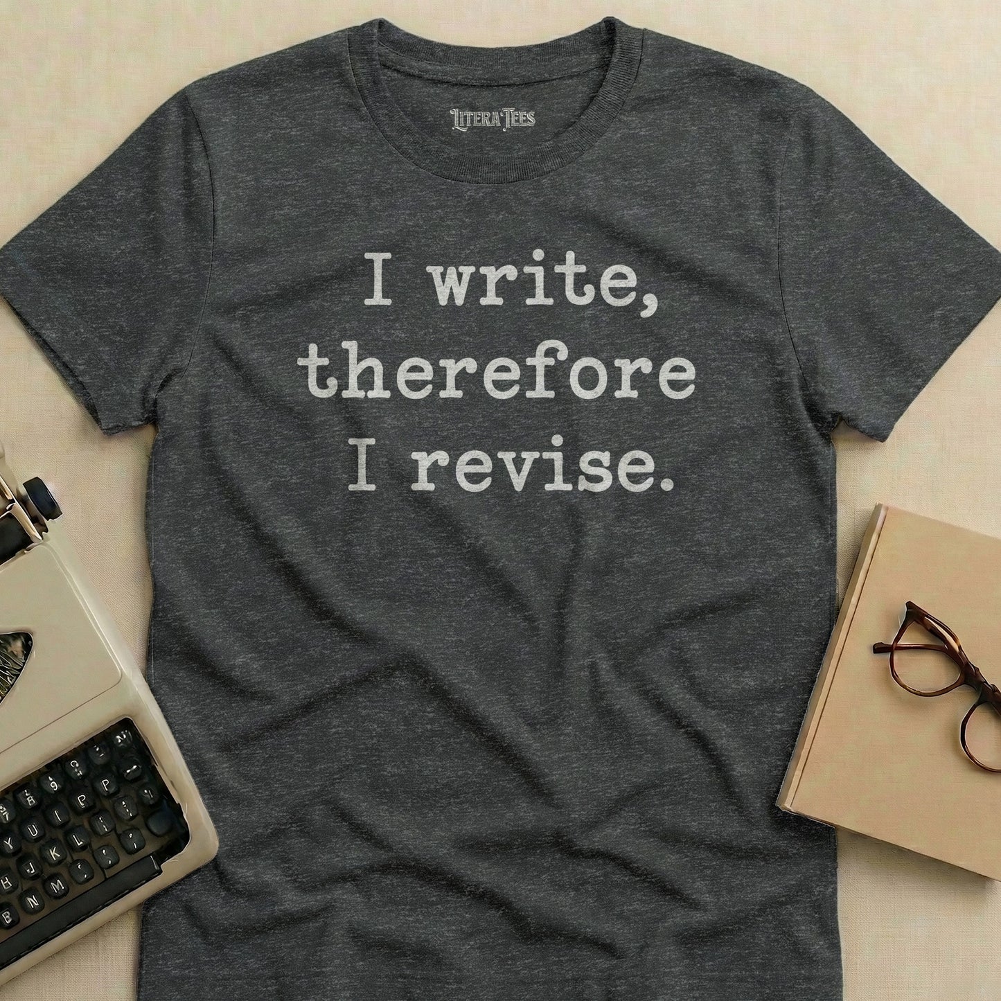 Dark gray t-shirt with white text "I write, therefore I revise."