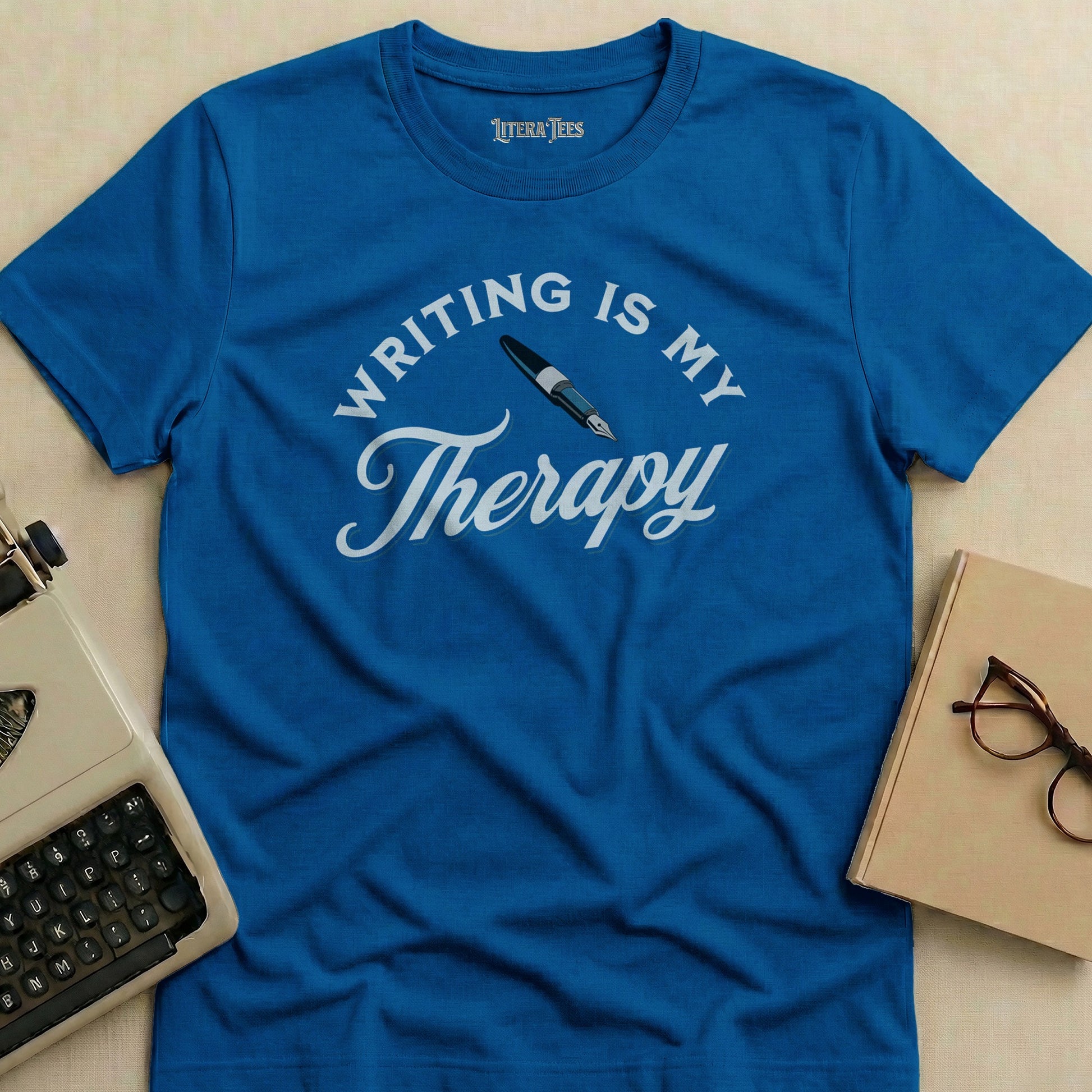 Blue t-shirt with "WRITING IS MY Therapy" in white text.