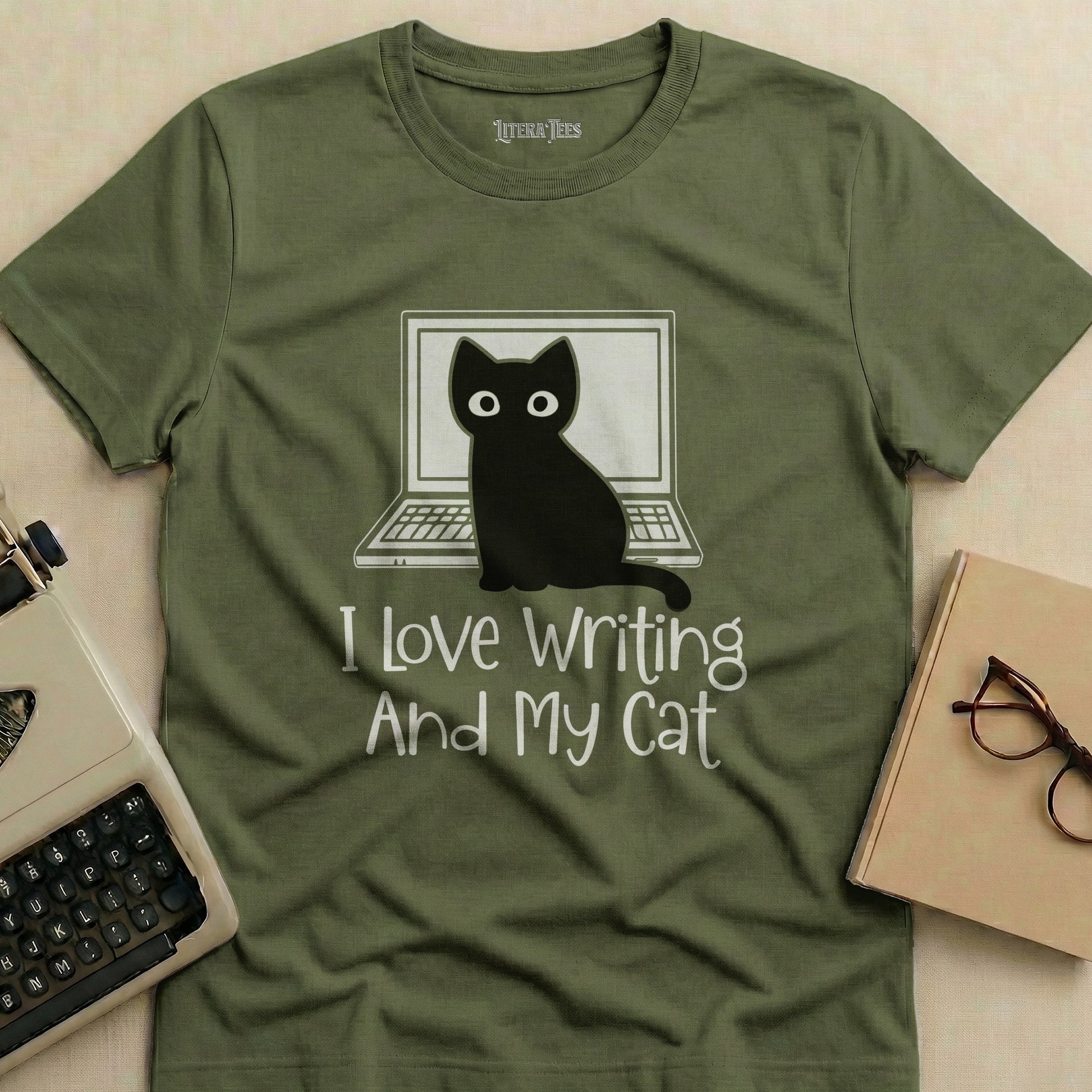 Green t-shirt with "I Love Writing And My Cat" text and cat on laptop graphic.