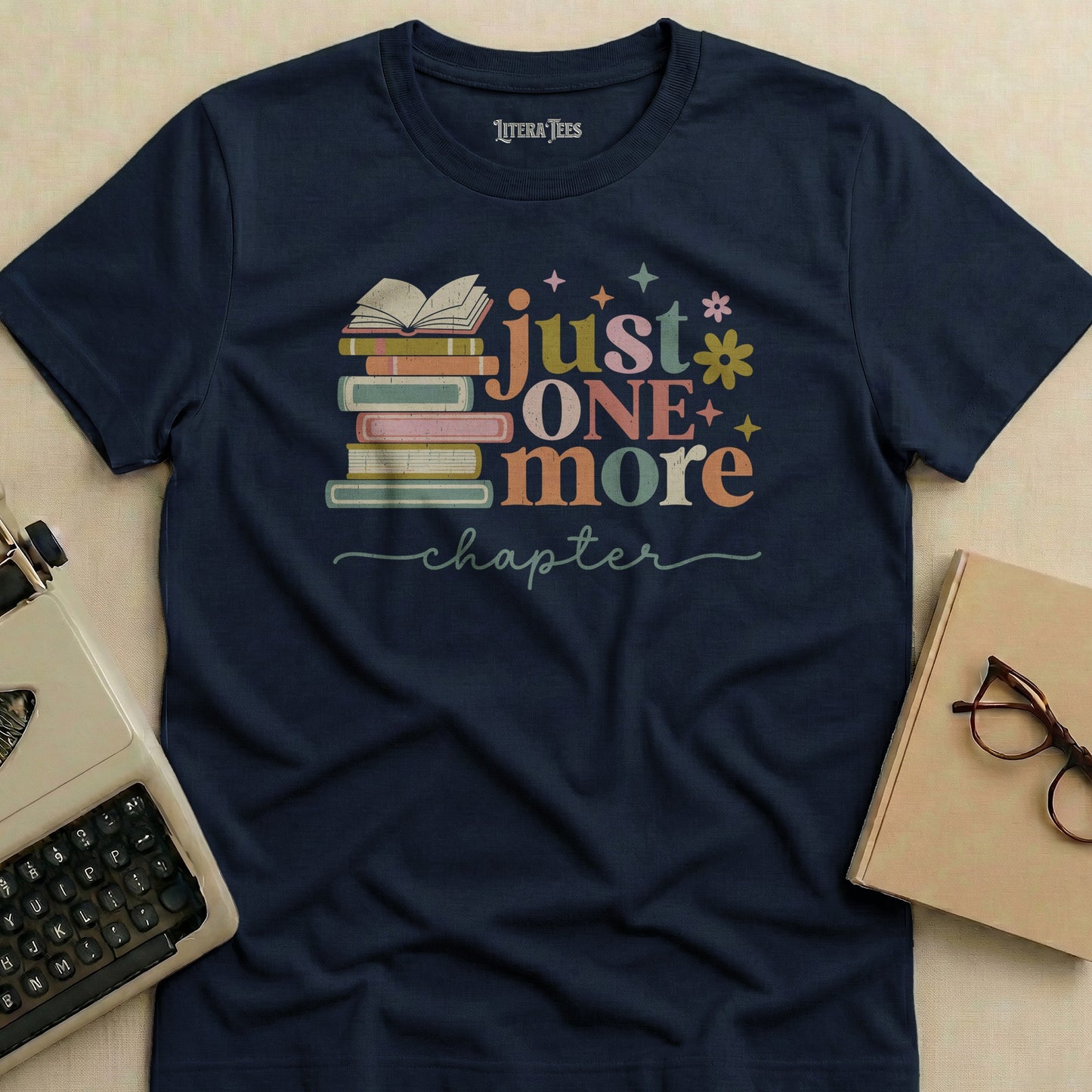 Navy t-shirt with "just one more chapter" and book graphic.