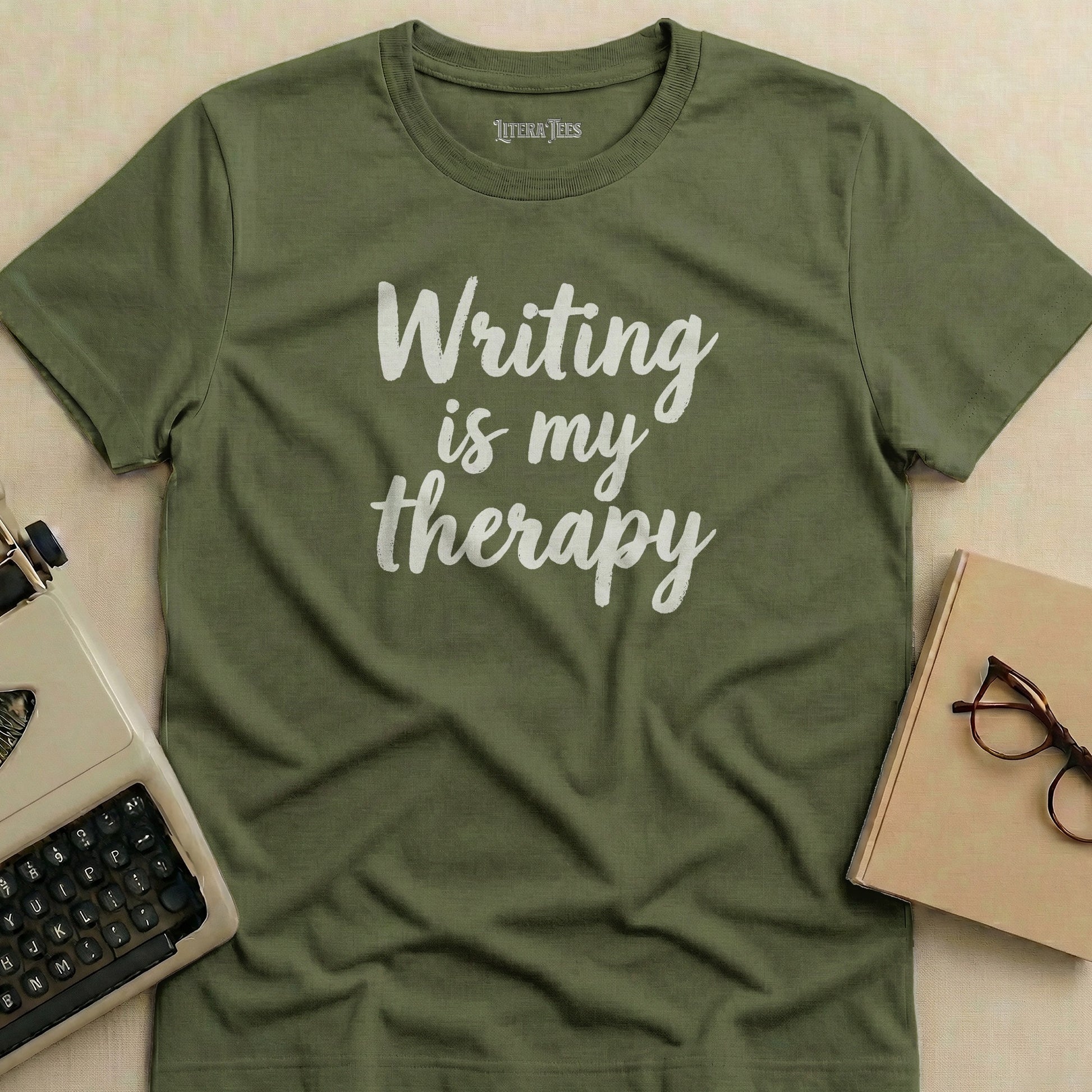 Olive green t-shirt with white text "Writing is my therapy."