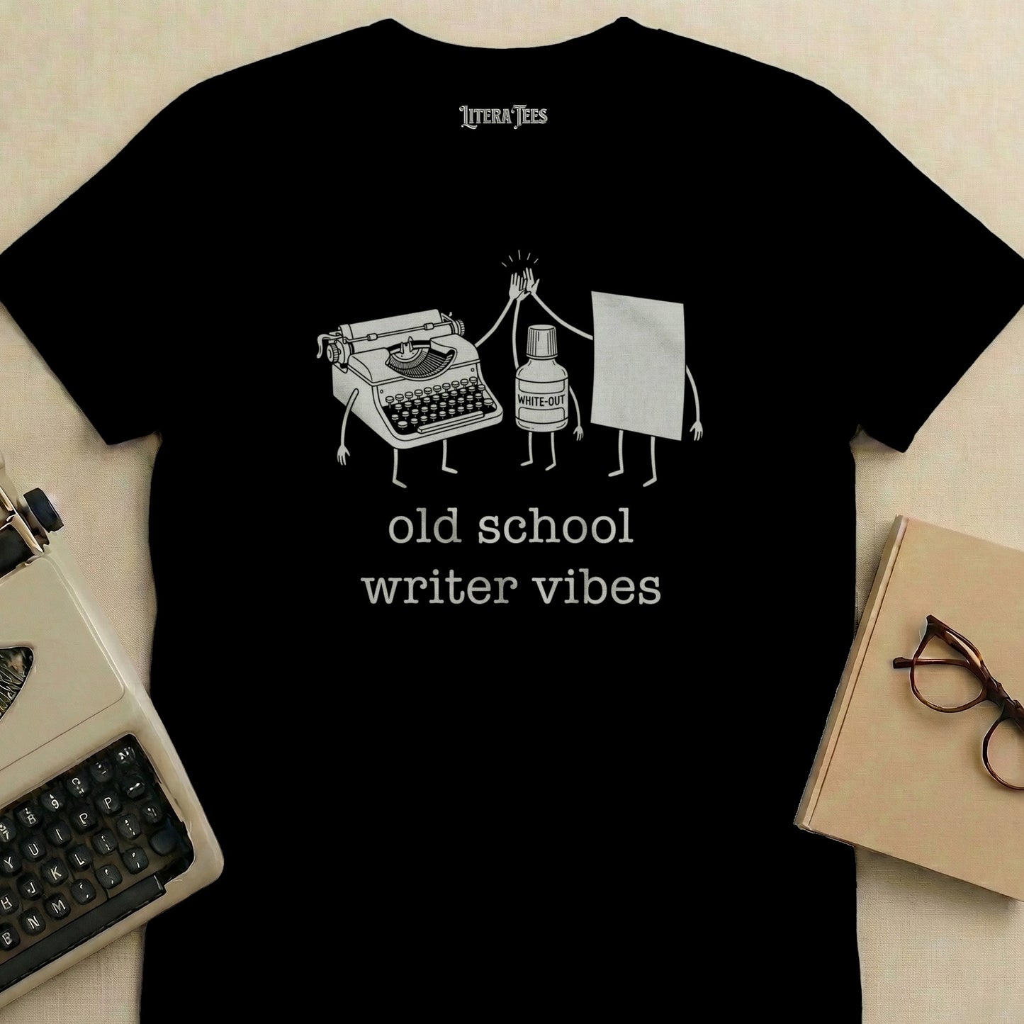 T-shirt with "old school writer vibes" and cartoon typewriter giving high five to a bottle of white-out.