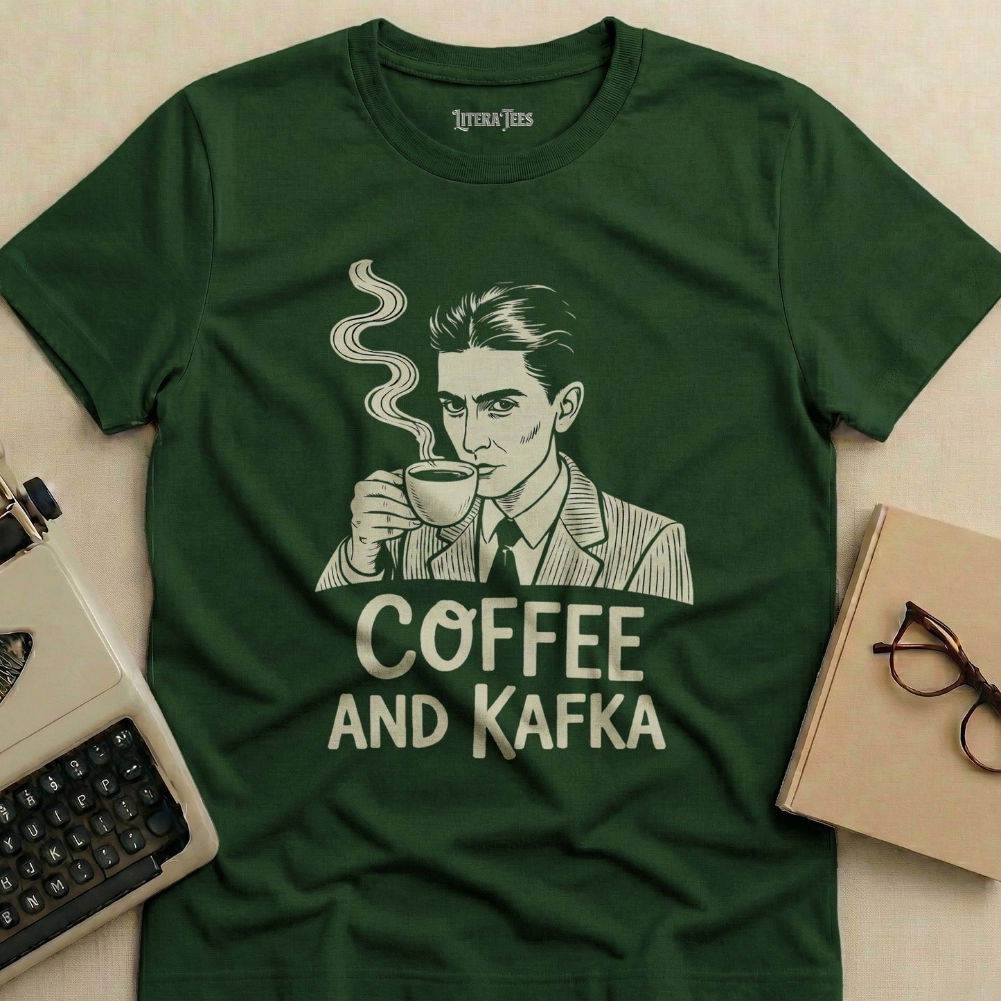 Dark green t-shirt with white text "COFFEE AND KAFKA" and drawing of a man drinking coffee.