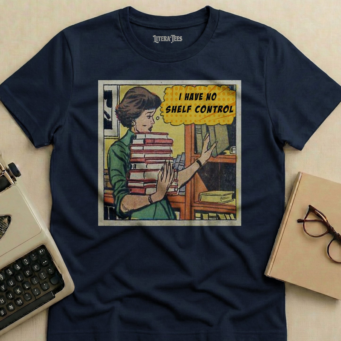T-shirt with comic panel of woman holding books and text "I HAVE NO SHELF CONTROL".