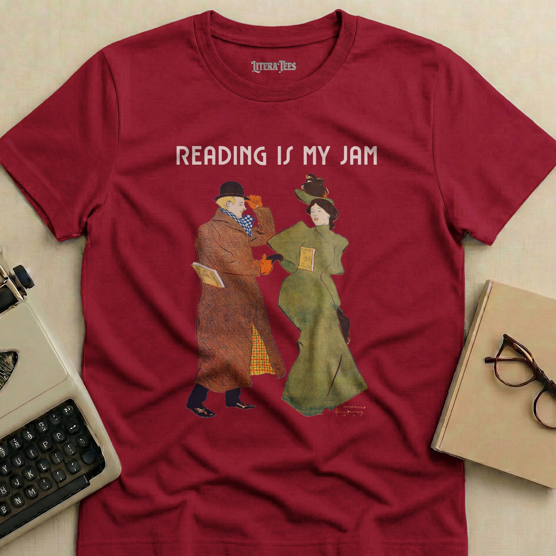 Burgundy t-shirt with "READING IS MY JAM" and artwork of two people reading.