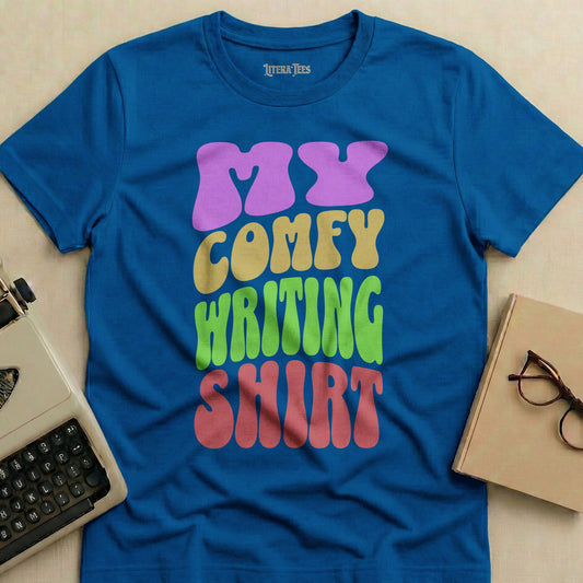 Blue t-shirt with "MY COMFY WRITING SHIRT" in colorful, retro lettering.