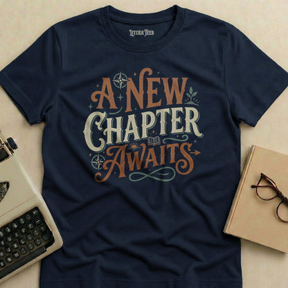 Navy t-shirt with "A New Chapter Awaits" text in decorative font.