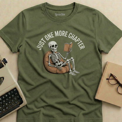 Olive green t-shirt with skeleton reading a book, "JUST ONE MORE CHAPTER" text.