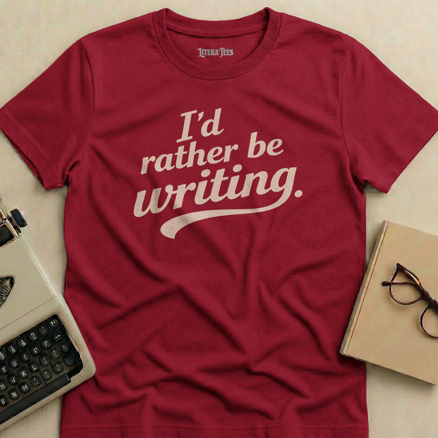 Burgundy t-shirt with "I'd rather be writing." in off-white text.