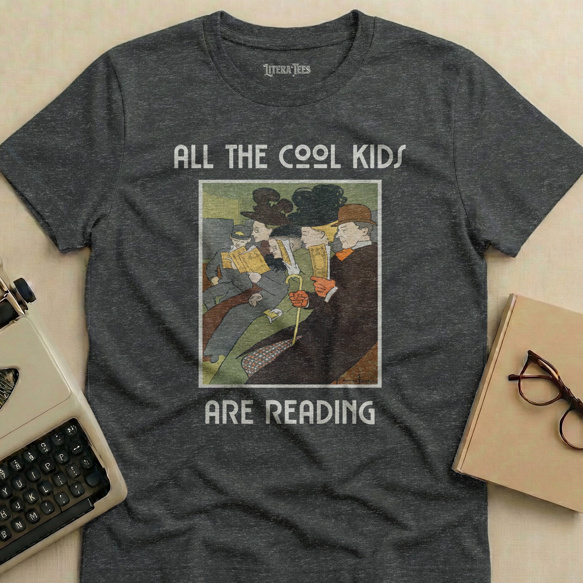 "All the Cool Kids Are Reading" text on a dark grey t-shirt with a vintage illustration.