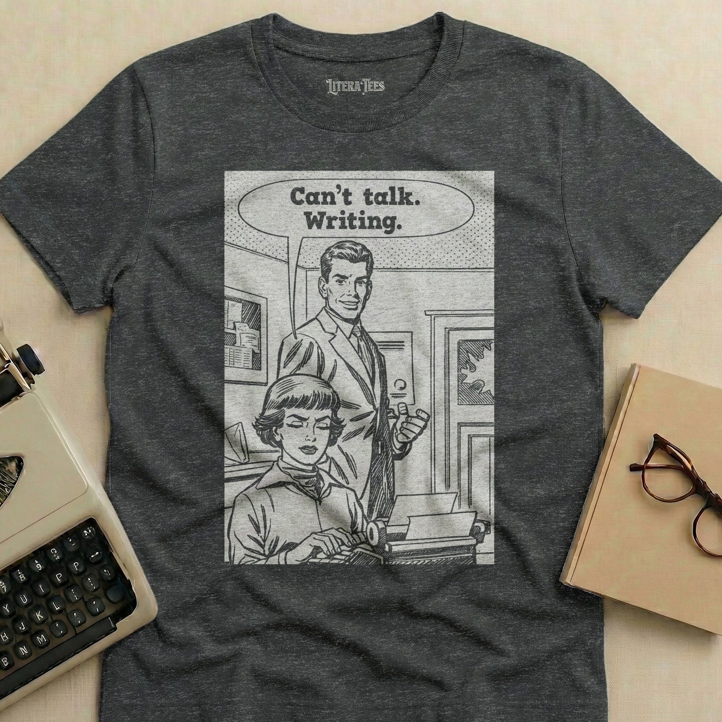 T-shirt with comic panel of couple and typewriter, text "Can't talk. Writing."