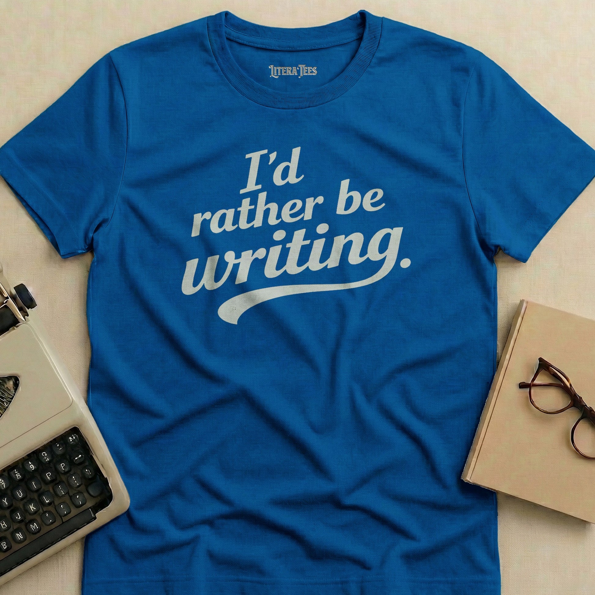 Blue t-shirt with "I'd rather be writing." in white text.