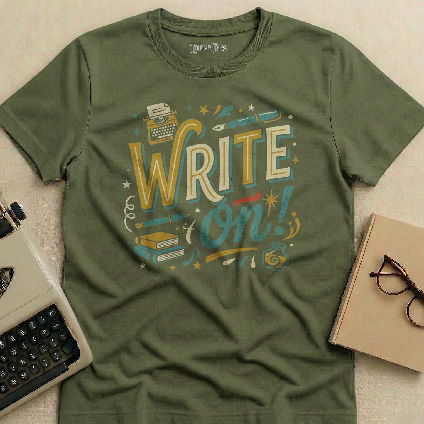 Green t-shirt with "Write on!" graphic featuring typewriter, books, and inkwell.