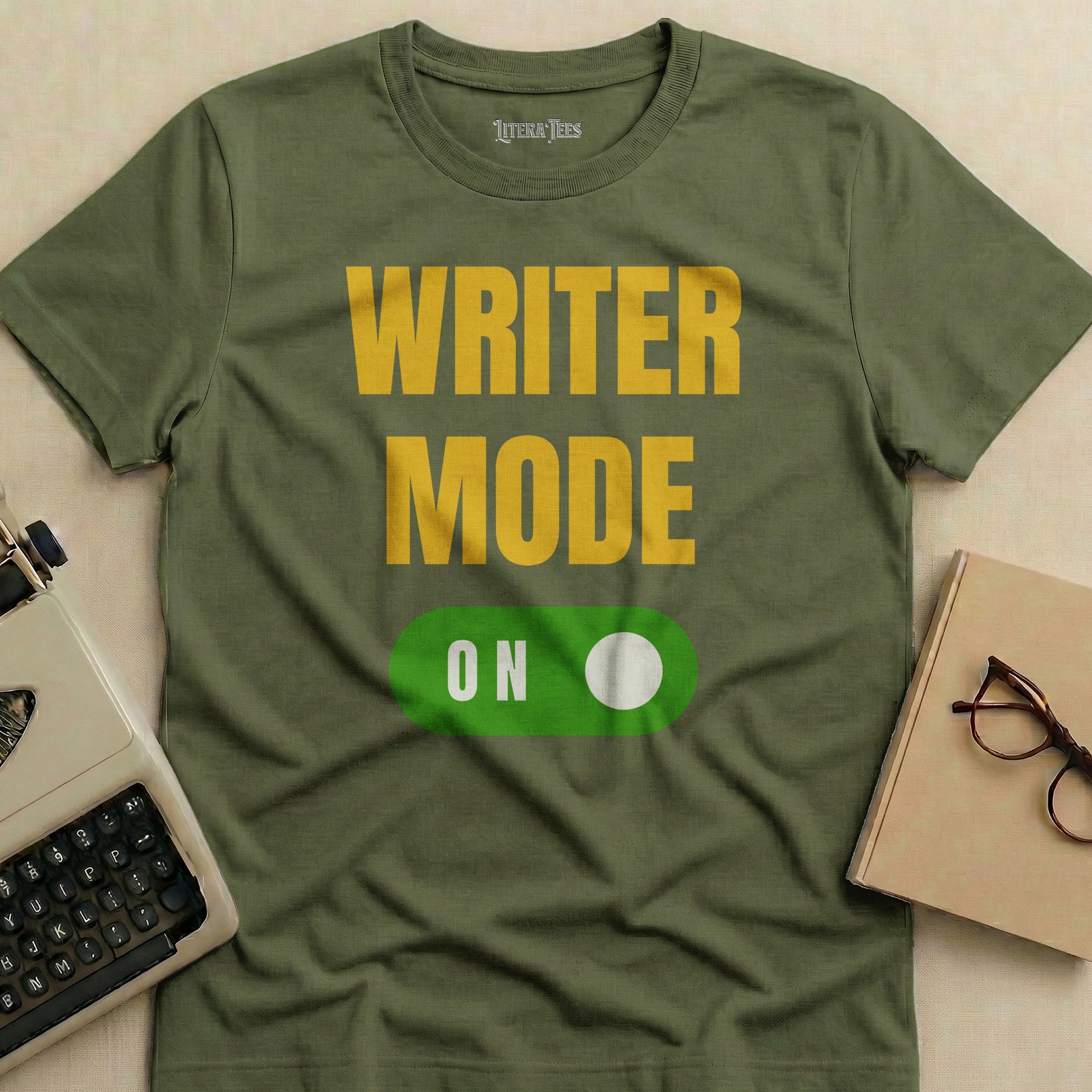 Olive green t-shirt with "WRITER MODE ON" text and a toggle switch.