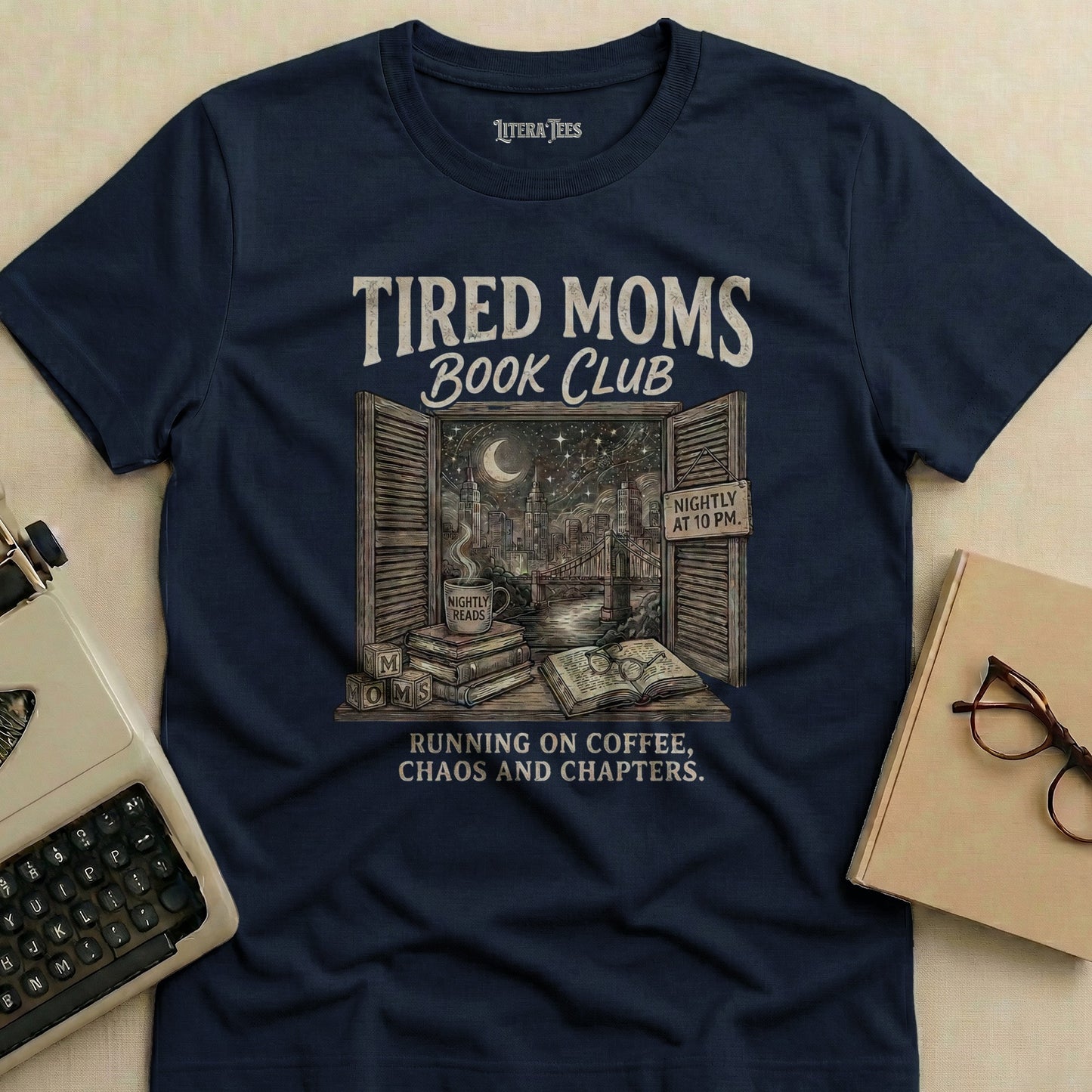 Navy t-shirt with "Tired Moms Book Club" design, featuring books and city skyline.