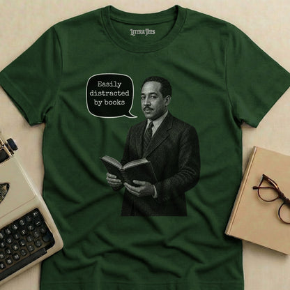 Green t-shirt with a graphic featuring a man reading a book and the text "Easily distracted by books".