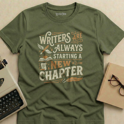 Olive green t-shirt with "WRITERS ARE ALWAYS STARTING A NEW CHAPTER" text.